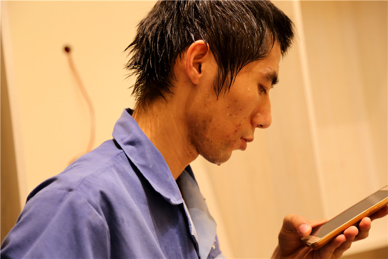 左右手家具安裝師傅頭發像剛從水里面出來，汗水不間斷的從頭發上流下來